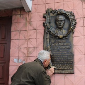 Микола Шляховий, онук Марка Шляхового, цілує меморіальну дошку дідові